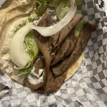 Hala Cafe - Gyro - A gyro sandwich featuring sliced meat, lettuce, onions, and sauce, served in a paper-lined basket with pita bread. - Mediterranean Near Me - Euless, Texas
