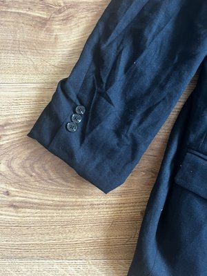 Suit jacket sleeve hemmed by Flora's Alterations