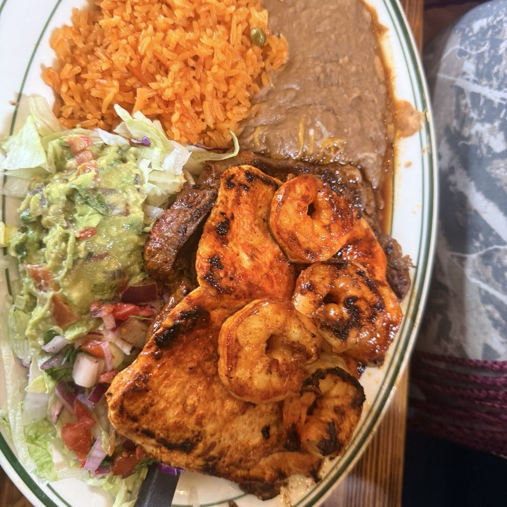 El Mezcal Mexican Restaurant Mount Dora - Steak chicken and shrimp with Rice and beans with side of lettuce with guacamole sour cream and tomatoes - Mexican Near Me - Mt Dora, Florida