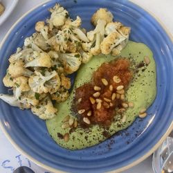 Roasted cauliflower with a tahini sauce, sumac pine nuts and tomato