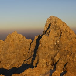 Fly Jackson Hole - Sunset on the peak of the Grand Teton in Grand Teton National Park. See the top of the summit of Grand Teton mountain