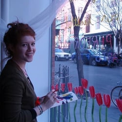 Brooklyn Strength owner, Cadence, painting the front window.