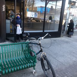 a bicycle parked next to a green bench