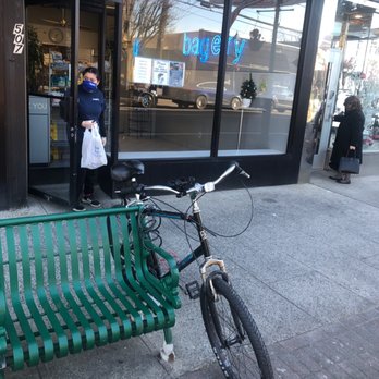 Bagelry - a bicycle parked next to a green bench - Bagels Near Me - Cedarhurst, New York
