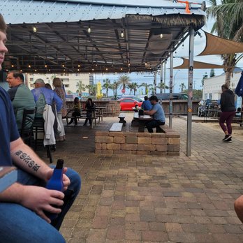 Mavericks Hangar Bar & Grill - a man sitting on a bench in a park - New American Near Me - Satellite Beach, Florida Mavericks Hangar Bar & Grill - a man sitting on a bench in a park - New American Near Me - Satellite Beach, Florida