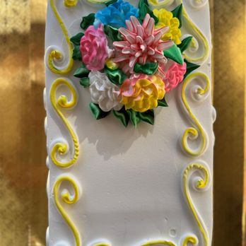 Ruben's Bakery - Pastel clásico y hermoso con un diseño elegante. Flores de crema batida de colores, decoradas a mano. - Bakeries Near Me - Fullerton, California