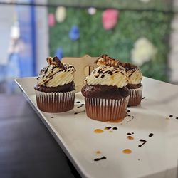 Sweet Affairz - Indulge in the decadent flavor of Snickers Cupcakes, topped with creamy frosting and studded with delicious bites of Snickers bars.