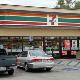 cars parked in front of a 7 - eleven