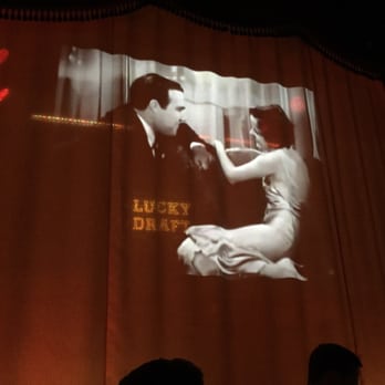 The Drifter - View from second row of tables, they have old movies looping before the girl comes on stage. - Speakeasies Near Me - Chicago, Illinois