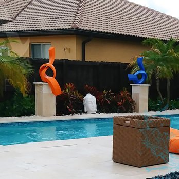Arroyo Pools - a pool with an orange and blue sculpture in the foreground - General Contractors Near Me Arroyo Pools - a pool with an orange and blue sculpture in the foreground - General Contractors Near Me