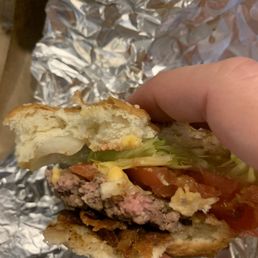 a hand holding a hamburger