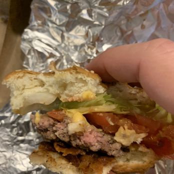 Five Guys - a hand holding a hamburger - Hot Dogs Near Me - Bethesda, Maryland