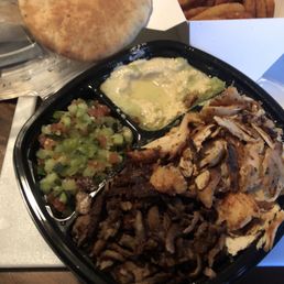 Mixed plate: chicken, beef, yellow rice underneath meats, hummus pita bread with side order of onion rings