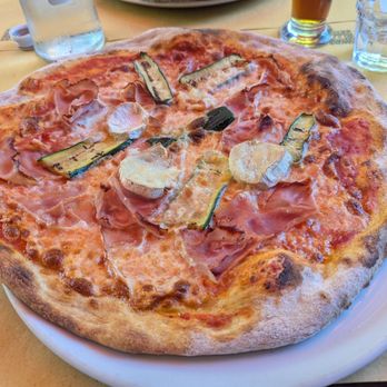Charlie Chaplin - Pizza with mozzarella, tomato sauce, grilled zucchini, raw ham, and goat cheese - Italian Near Me - Garbagnate Milanese, Michigan Charlie Chaplin - Pizza with mozzarella, tomato sauce, grilled zucchini, raw ham, and goat cheese - Italian Near Me - Garbagnate Milanese, Michigan