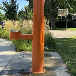 Drinking fountain. Basketball court in the background.