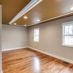 One Call Home Team - Master Bedroom Renovation with Drop down ceiling with led accent lighting, can lights, refinished original hardwood floors and new windows.