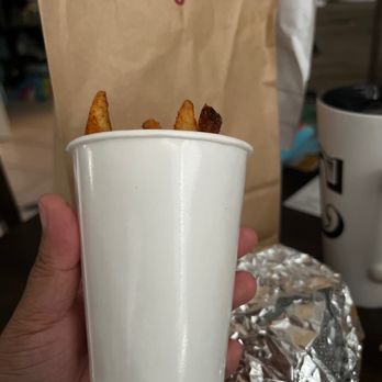 Five Guys - a hand holding a cup of fries - Burgers Near Me - Winter Springs, Florida Five Guys - a hand holding a cup of fries - Burgers Near Me - Winter Springs, Florida