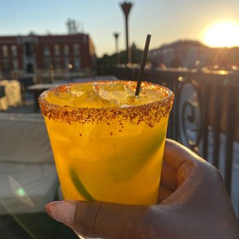 Stixx - a hand holding a glass with a drink in it - Lounges Near Me - Indianapolis, Indiana