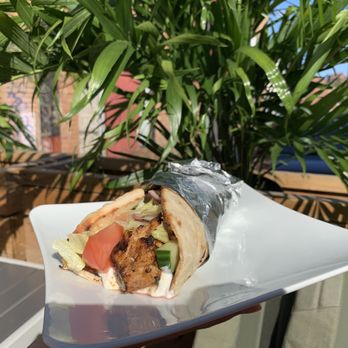 TROY - a hand holding a sandwich with meat and vegetables - Greek Near Me - Montreal, Quebec TROY - a hand holding a sandwich with meat and vegetables - Greek Near Me - Montreal, Quebec