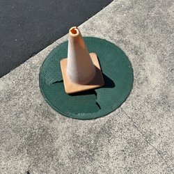 Captain Kid Amusement Park - Busted plastic manhole cover in the sidewalk between the parking lot and entrance to the park. Why is this not repaired?