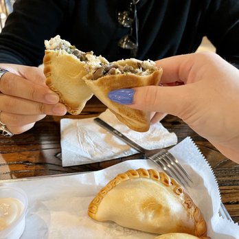 DelSur Empanadas - a person holding a piece of empanada - Empanadas Near Me - Minneapolis, Minnesota