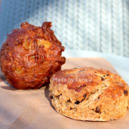 Carrot Muffin - A muffin and a scone are placed on a white plate with a paper liner, photographed outdoors with a blurred background.