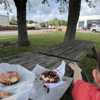 Bright Spot Donuts - Picnic table tasting across from Bright Spot. Featuring chocolate and a little nibble out of doughnut special. - Donuts Near Me - Raleigh, North Carolina Bright Spot Donuts - Picnic table tasting across from Bright Spot. Featuring chocolate and a little nibble out of doughnut special. - Donuts Near Me - Raleigh, North Carolina