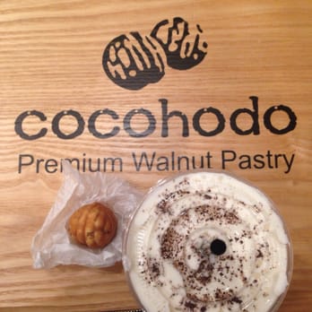 Cocohodo - Unwrapped walnut pastry and the iced sea salt latte with the Cocohodo logo on the tables - Desserts Near Me - Flushing, New York Cocohodo - Unwrapped walnut pastry and the iced sea salt latte with the Cocohodo logo on the tables - Desserts Near Me - Flushing, New York
