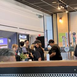 BurgerFi - This woman, in a mask but sick, WIPED HER NOSE with a napkin and then continued to serve/touch food without washing hands