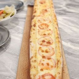 a long piece of pizza on a cutting board