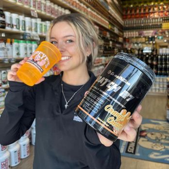 Popeye's Supplements Nanaimo - a woman holding a can and a can of protein - Health Markets Near Me - Nanaimo, British Columbia Popeye's Supplements Nanaimo - a woman holding a can and a can of protein - Health Markets Near Me - Nanaimo, British Columbia