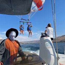 Chelan Parasail & Watersports - Summer Lake Chelan parasailing experience. Two people enjoying a high-flying, safe watersports adventure over the clear lake ...
