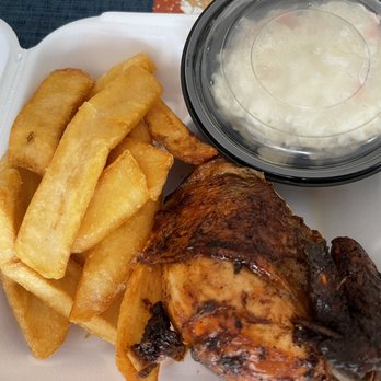 Pollo Peru - El Americano Meal - Fries and Cole Slaw - A meal featuring thick-cut fried potato fries, a roasted chicken leg, and a container of coleslaw on a white tray. - Peruvian Near Me - Reston, Virginia