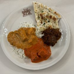 Taste of Bombay Indian Restaurant - Counter clockwise from left: Chicken tikka masala, butter chicken, goat curry, and garlic naan.