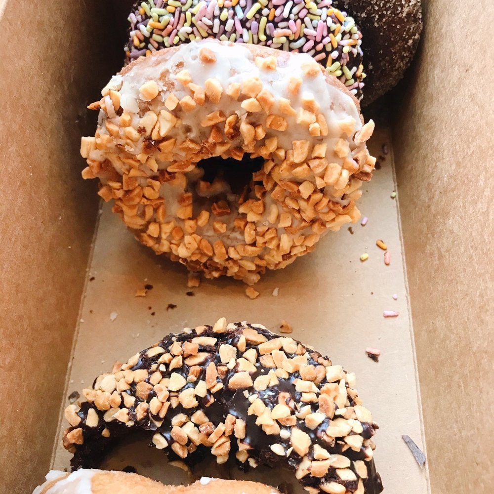 Mighty-O Donuts - From top to bottom: chocolate mint, sprinkles, nutty French toast, nutty chocolate, nutty vanilla. - Donuts Near Me - Seattle, Washington Mighty-O Donuts - From top to bottom: chocolate mint, sprinkles, nutty French toast, nutty chocolate, nutty vanilla. - Donuts Near Me - Seattle, Washington