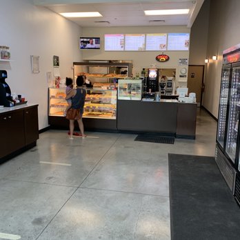 Grand donuts - a woman standing in front of the counter - Donuts Near Me - Round Rock, Texas