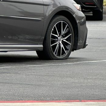 Longo Toyota - Service agent driving around a clients car on a flat. - Car Dealers Near Me - El Monte, California Longo Toyota - Service agent driving around a clients car on a flat. - Car Dealers Near Me - El Monte, California
