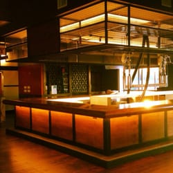 Pioneer Wood & Steel - Baker st pub. Custom welded overhead liquor cages and walnut trimmed in steel bar face with a walnut bar top