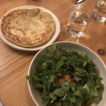 Emmer & Rye - Paneer cheese block underneath delicious greens, served with house-baked naan (sooo good) - Tapas/Small Plates Near Me - Austin, Texas