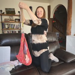 Sierra Homebirth - Postpartum visit. Weighing baby on the living room couch.