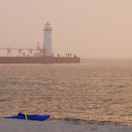 Manistee lighthouse. 1st street beach pier and lighthouse (across the river channel) right behind