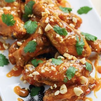 Legacy Lounge - a plate of chicken wings covered in sauce and garnished with peanuts - Lounges Near Me - Ansonia, Connecticut Legacy Lounge - a plate of chicken wings covered in sauce and garnished with peanuts - Lounges Near Me - Ansonia, Connecticut
