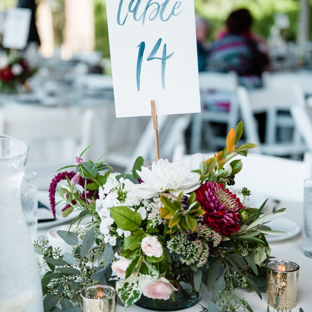 Emerald Petals - Example of the fantastic table arrangements by Hilary. Photo Credit: Laura Morsman Photography/ Table signs: JessicaRCrowell.com - Florists Near Me