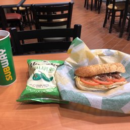 a bag of chips and a sandwich on a table a bag of chips and a sandwich on a table