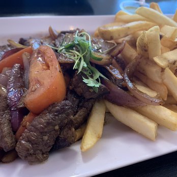 Mixturas Fusion - lomo saltado nikkei - A dish featuring sautéed beef with tomatoes, onions, and herbs served alongside French fries. - Peruvian Near Me - Orem, Utah