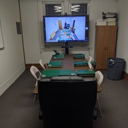 Advanced conference room setup utilized for training and certifications; contains wide screen TV, computer, web cam and controllable stand.