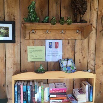 Frog Pond Cafe - a shelf of books and a frog figurine - Coffee & Tea Near Me - Chéticamp, Nova Scotia