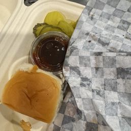 Hawaiin roll with side of bbq sauce and pickles Hawaiin roll with side of bbq sauce and pickles