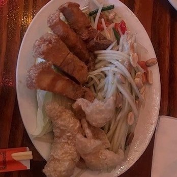 Glai Baan - Somtum Thai  with Crispy Pork Belly - A dish with fried chicken, beef strips, bean sprouts, and vegetables served with noodles on an oval plate. - Thai Near Me - Phoenix, Arizona