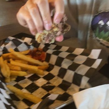 Wild Goose Saloon - a person eating a burger and fries - Music Venues Near Me - Parker, Colorado Wild Goose Saloon - a person eating a burger and fries - Music Venues Near Me - Parker, Colorado